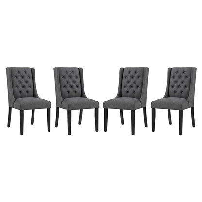 Set of four gray tufted dining chairs with fabric upholstery and tapered black legs.