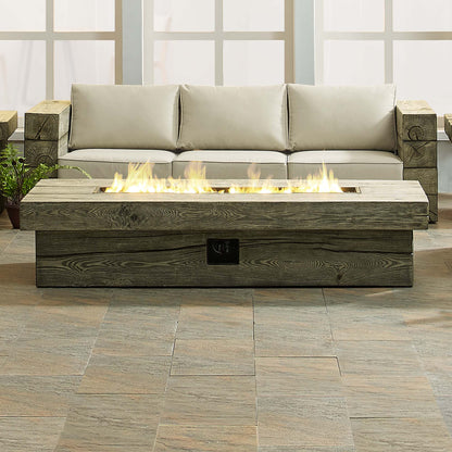 Rectangular gray wood-look fire pit table with flames on a tiled outdoor patio.