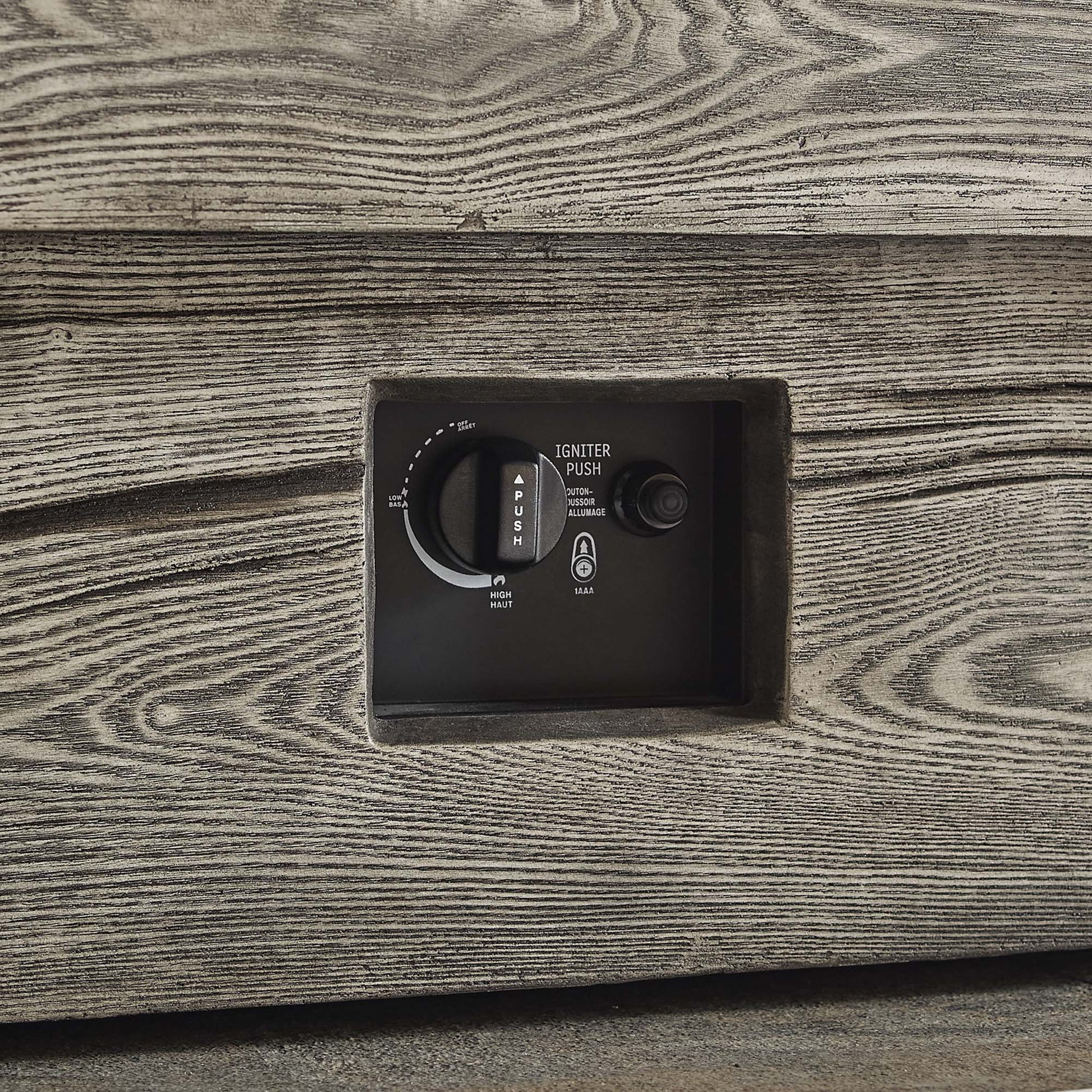 Rectangular outdoor fire pit table in light gray with a black control panel featuring ignition dial and push button.