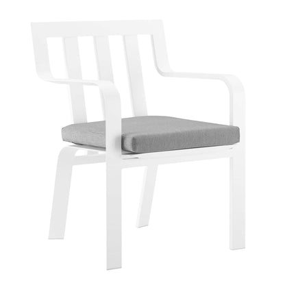 White modern armchair with slatted back, curved arms and gray seat cushion.