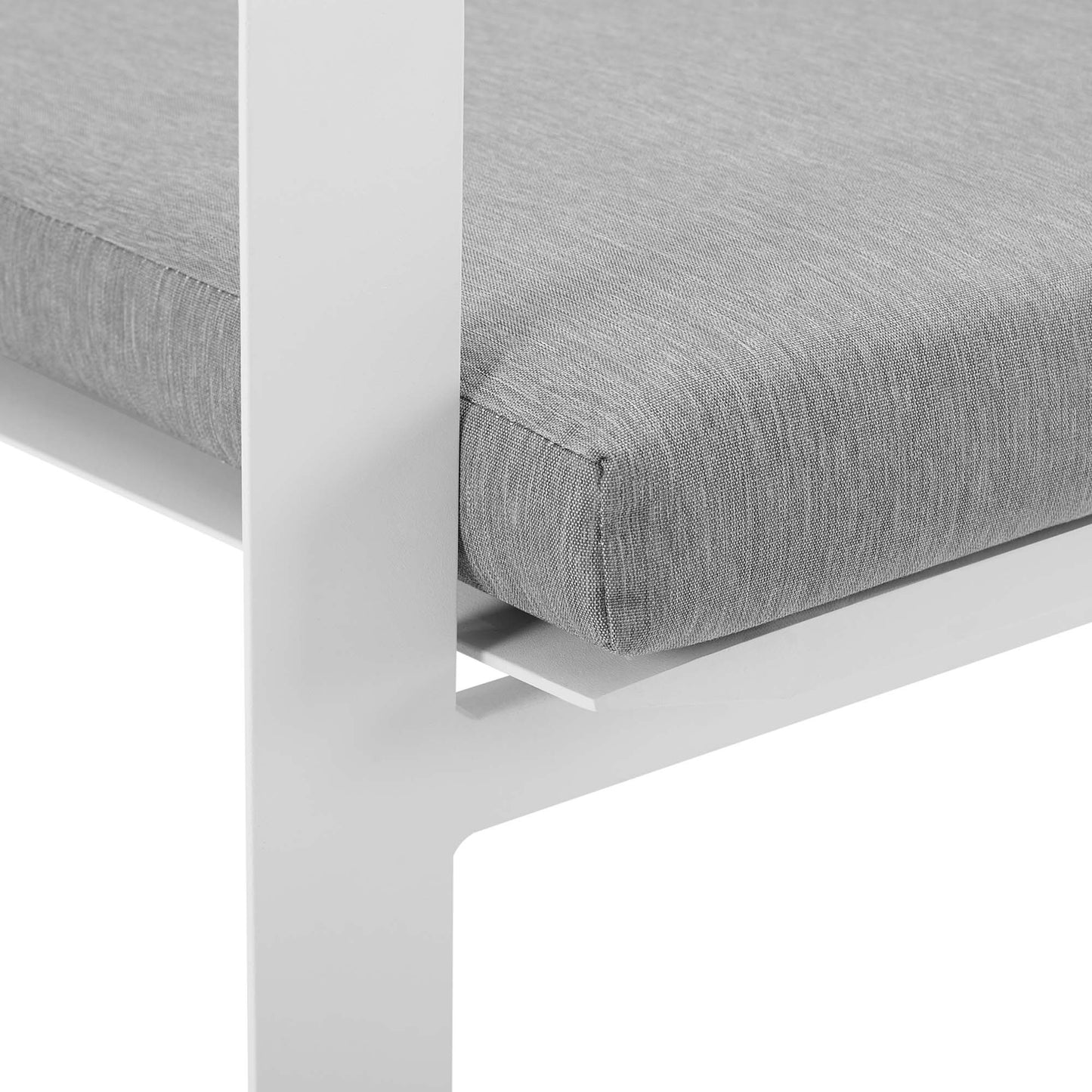 White aluminum stackable outdoor dining armchair with a light gray cushion; close-up of the leg and seat edge.