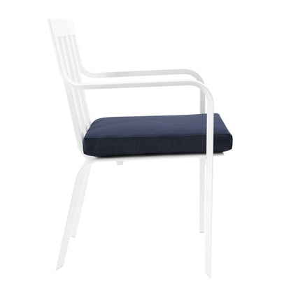 White aluminum outdoor dining armchair with navy cushion, curved arms, slatted back.