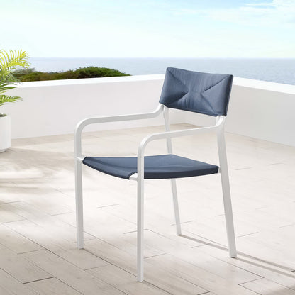 White aluminum outdoor dining armchair with navy cushions on the seat and back, curved arms, in an outdoor terrace setting.
