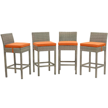 Set of four grey wicker bar stools with orange cushions and backrests.
