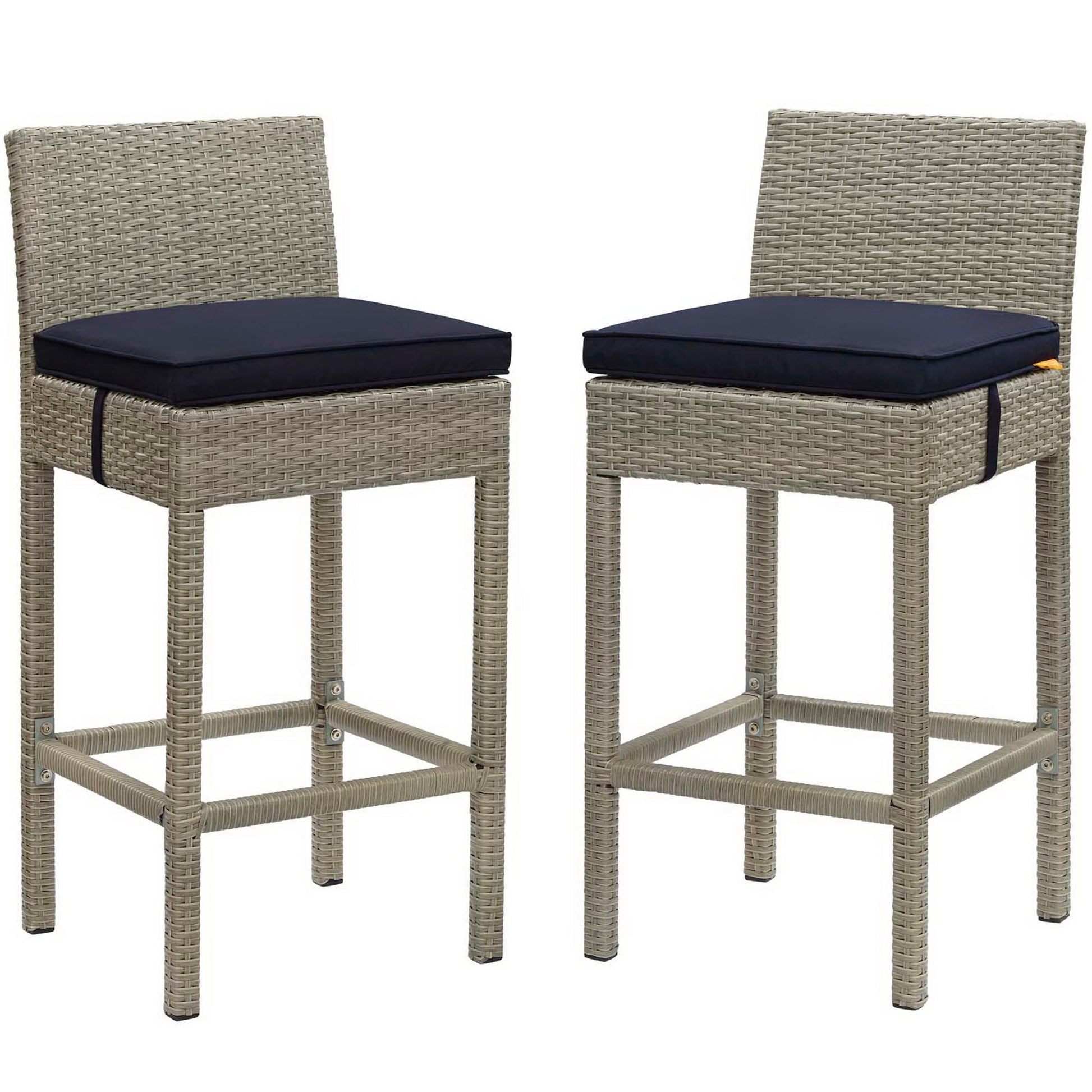 Pair of light gray wicker outdoor bar stools with navy cushions, square woven frames & footrests.