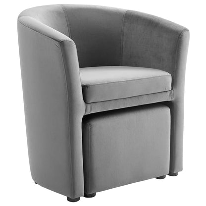 Gray curved velvet armchair and ottoman set with a rounded back.