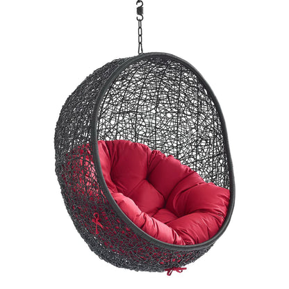 Black woven hanging egg chair with plush red cushion and chain suspension.