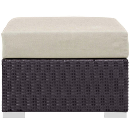 Dark brown woven wicker outdoor patio seating piece with a beige cushion & metal feet, part of a 5-piece set with a fire pit.