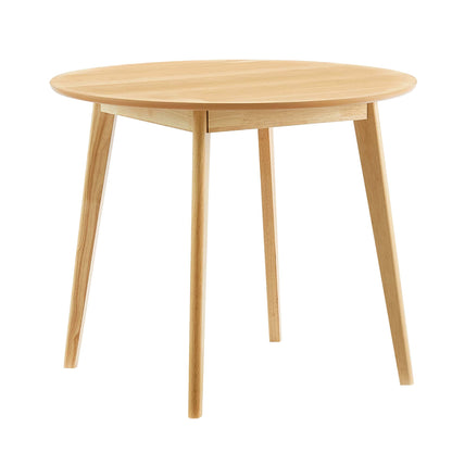 Round light oak dining table with tapered legs, mid-century modern.
