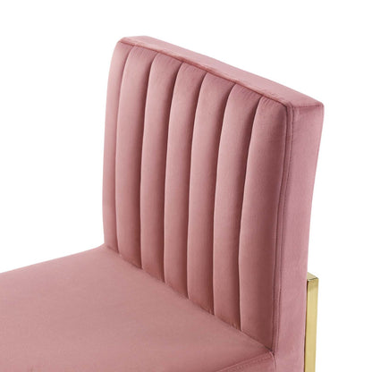 Dusty rose velvet dining chair with vertical channel tufting and a gold-tone sled base.