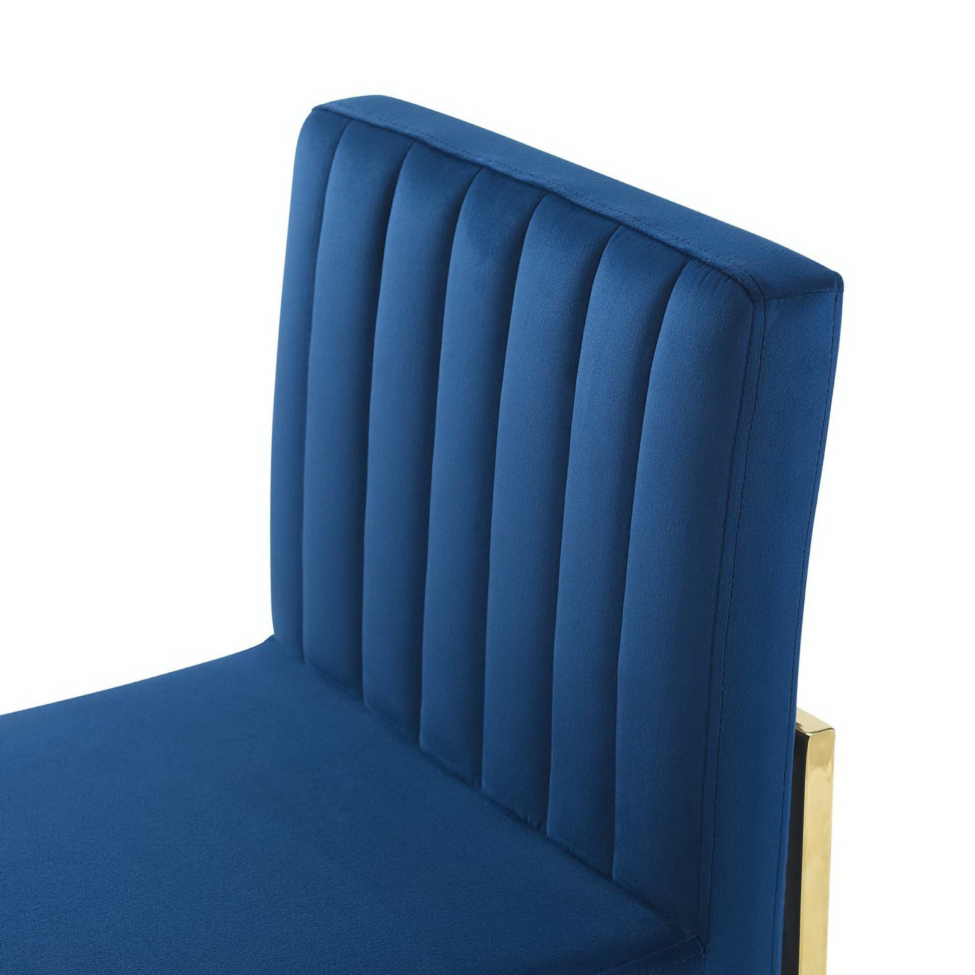 Navy blue velvet dining chair with vertical channel tufting, high back, and gold metal frame.