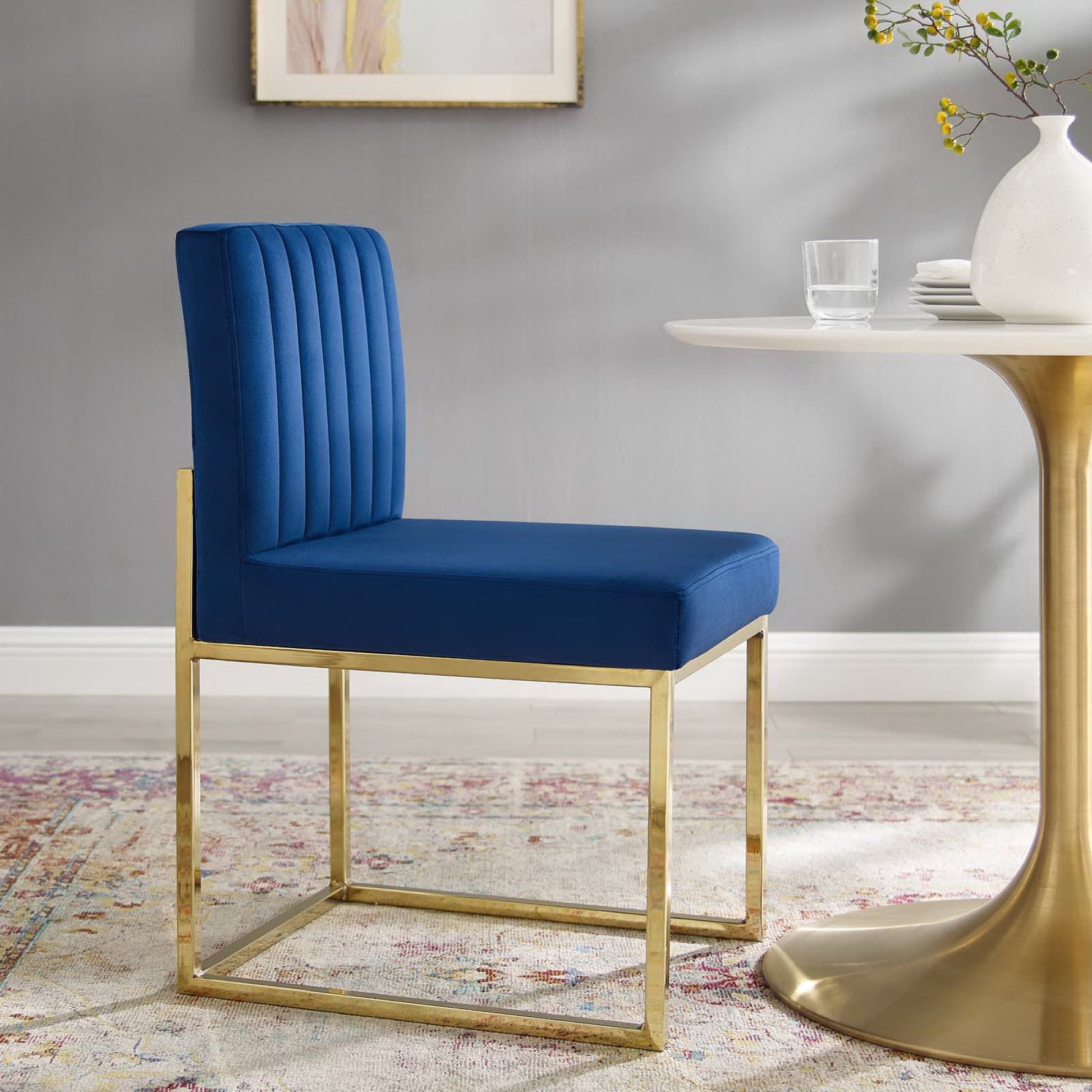Navy velvet channel-tufted dining chair with a gold metal frame.