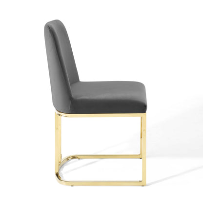 Grey velvet upholstered dining chair with a gold-tone sled base