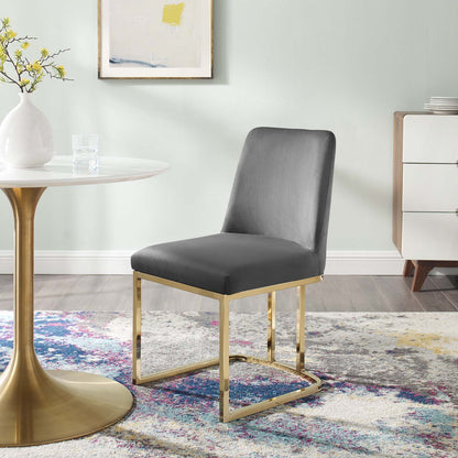 Grey upholstered dining chair with a gold-tone sled-base beside a round glass table in a modern pastel dining room.