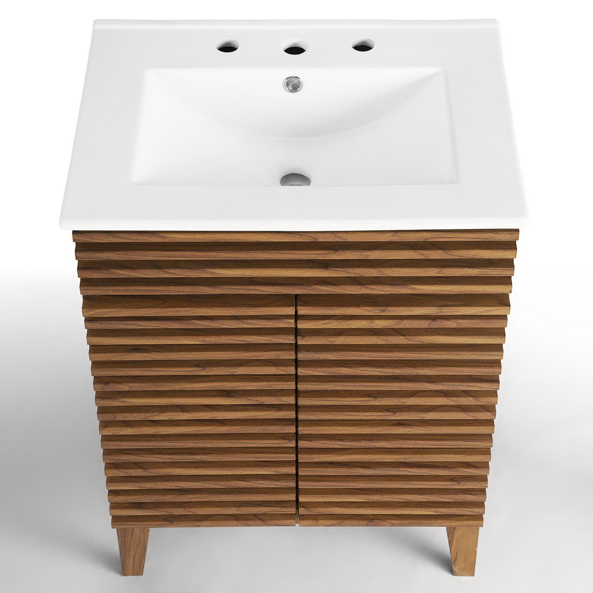 White slat-front bathroom vanity with two doors, short legs, and a white rectangular sink with three faucet holes.