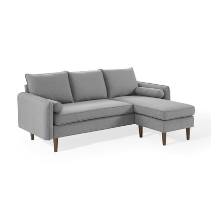 Light gray fabric sectional sofa in an L-shape with a right-side chaise, three back cushions, and wooden legs.