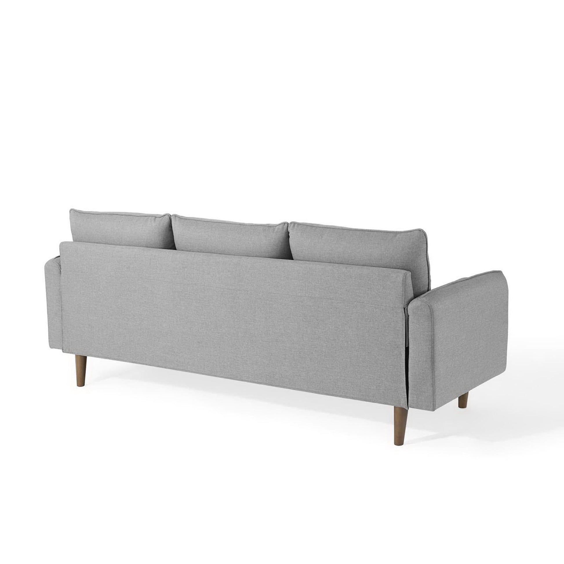 Light gray fabric sectional sofa with wooden tapered legs, three back cushions, square arms, mid-century modern style.