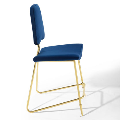 Navy blue velvet upholstered counter stool with gold metal sled legs and tall padded backrest.