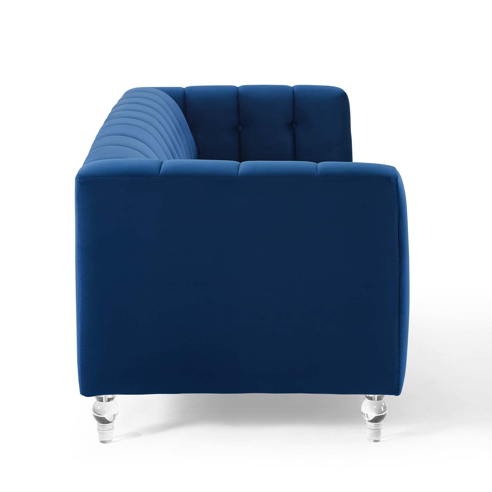 Navy blue velvet sofa with tufted back cushions, chrome legs, modern lounge seating.