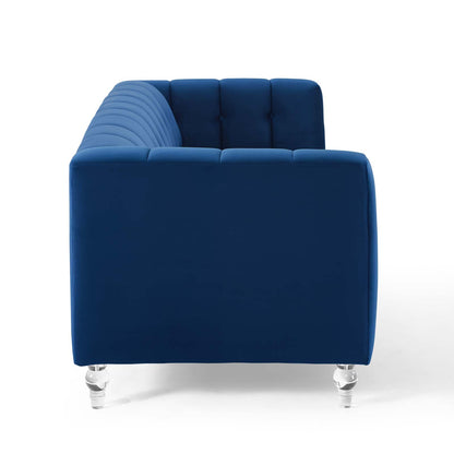 Navy blue velvet sofa with tufted back cushions, chrome legs, modern lounge seating.