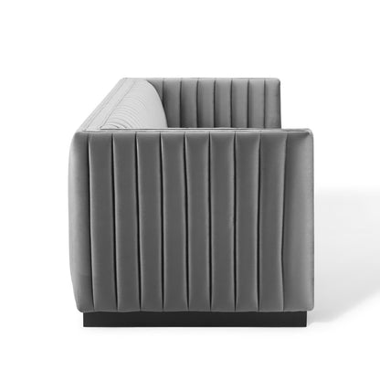 Gray velvet channel-tufted sofa with square silhouette and low black pedestal base.