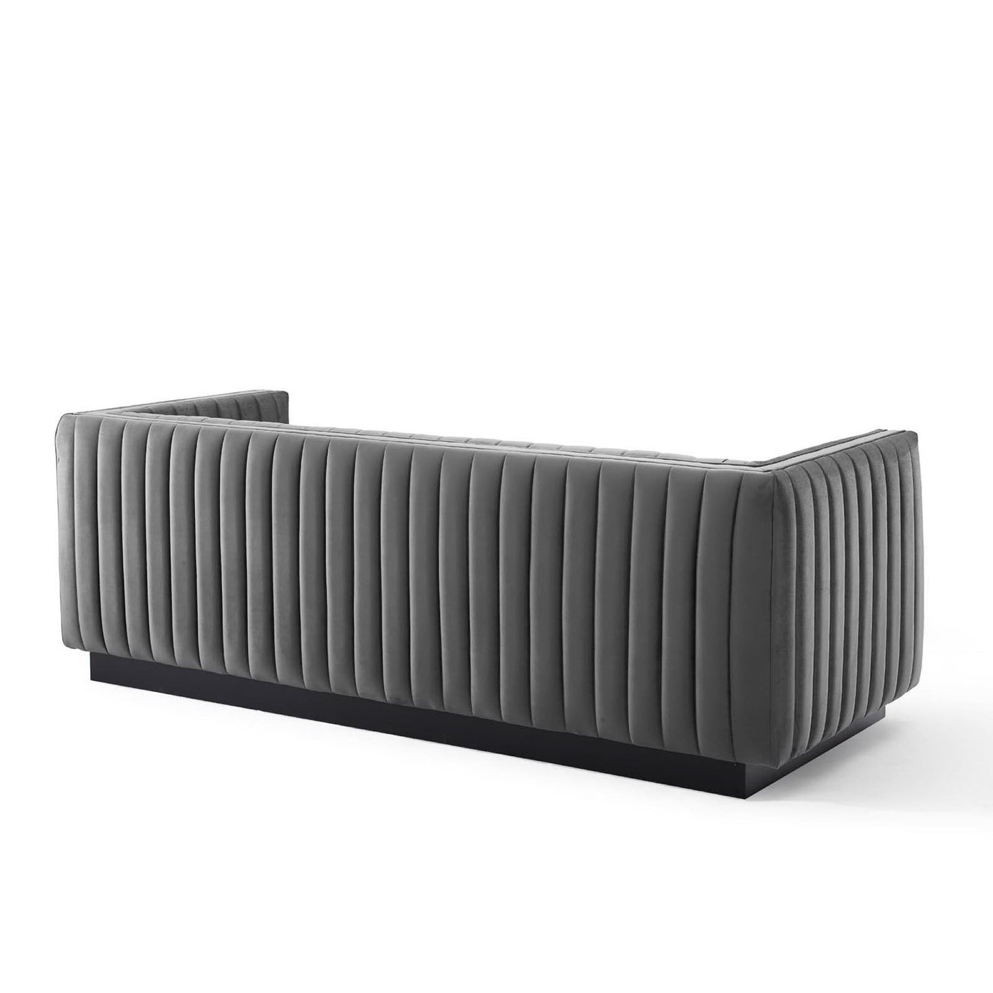 Grey channel-tufted velvet sofa with vertical ridges and a black plinth base, modern lounge piece.