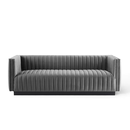 Grey velvet sofa with vertical channel tufting, low-profile arms and sleek contemporary lounge design.