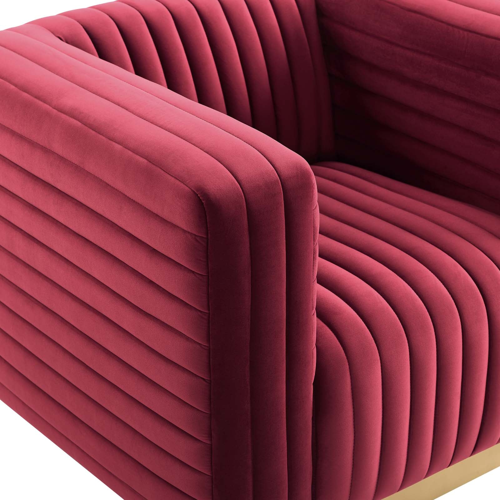 Burgundy velvet lounge armchair with vertical channel-stitched pleats and padded arms.