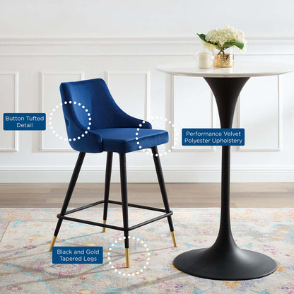 Navy performance velvet polyester upholstery counter stool with button tufted detail and black and gold tapered legs.