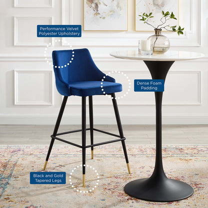 Navy velvet bar stool with performance velvet upholstery, dense foam padding, and black tapered legs with gold tips.