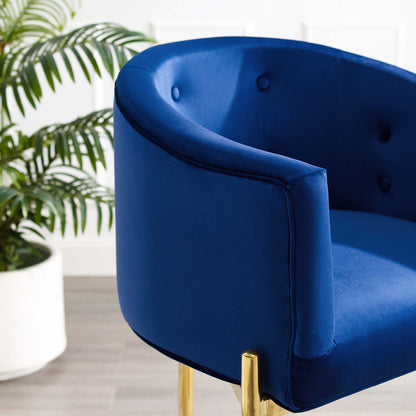 Navy blue velvet tufted counter stool with curved back and gold legs.