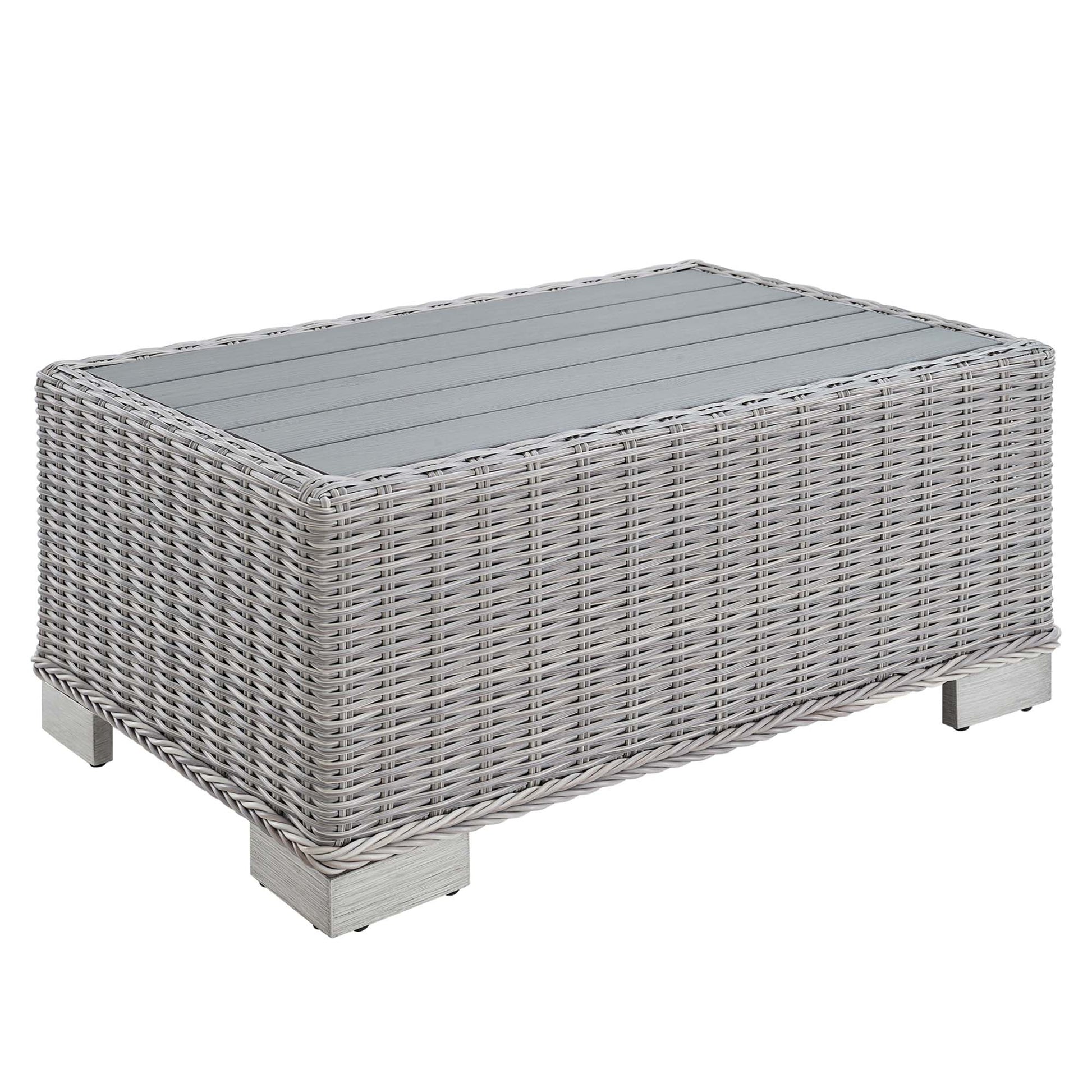 Rectangular gray wicker coffee table with glass top and short square metal legs.