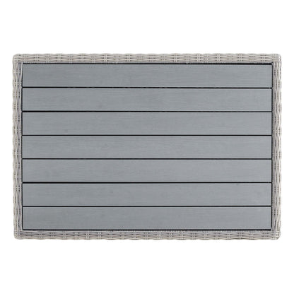 Rectangular gray slatted panel framed in light wicker, modern outdoor coffee table.