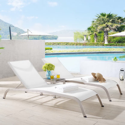 Two white outdoor mesh seating chairs with a small table by a bright resort pool, with towels, a hat, and drinks nearby; part of a three-piece outdoor patio mesh seating set.