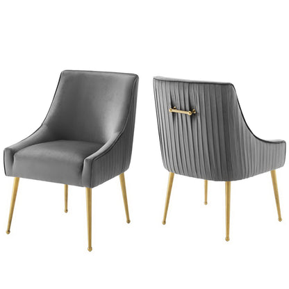 Pair of gray velvet dining chairs with curved arms, pleated back & gold tapered legs.