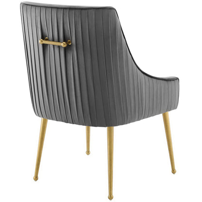 Gray ribbed velvet dining chair with curved back, gold tapered legs and brass back handle.