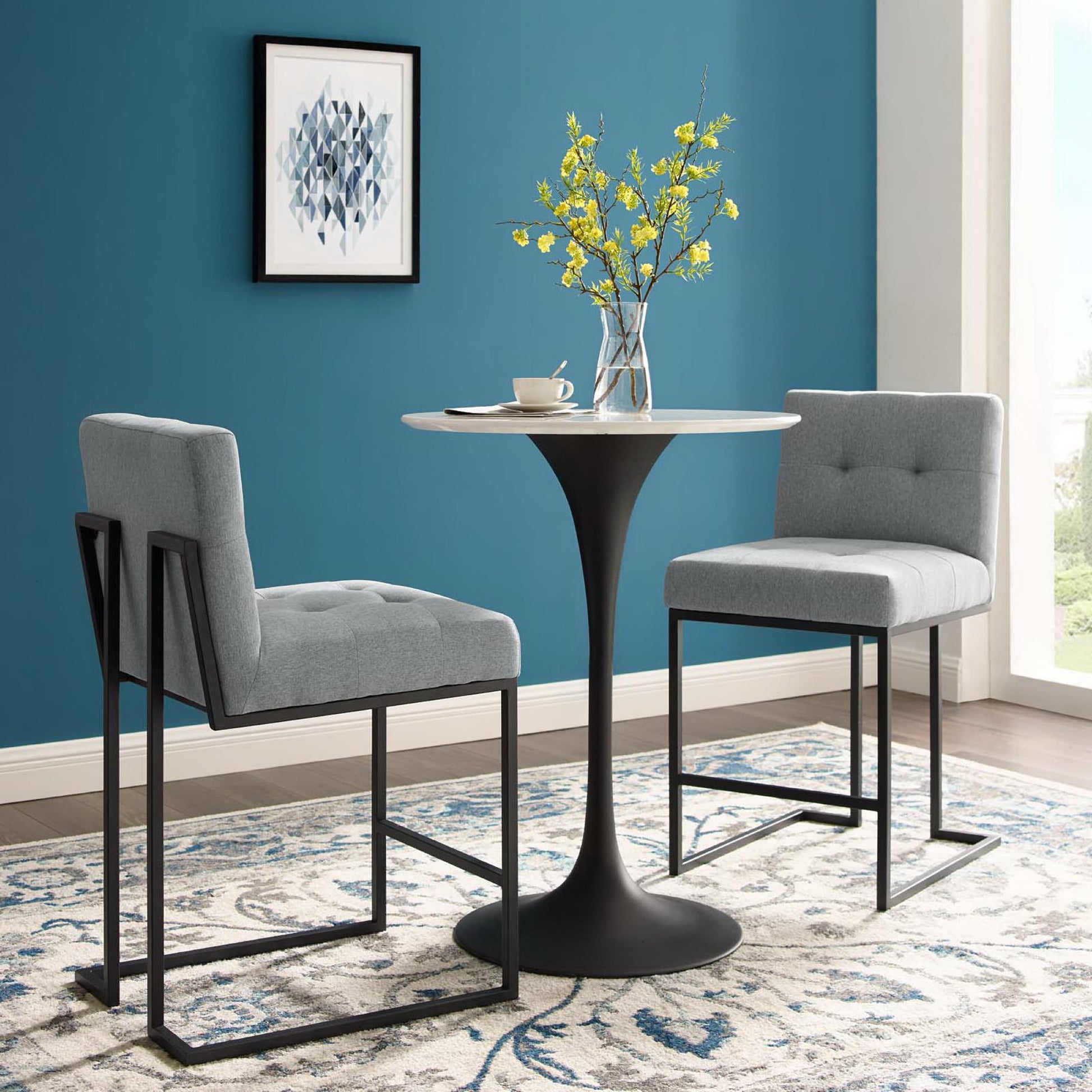Two gray upholstered counter stools with black stainless steel frames.