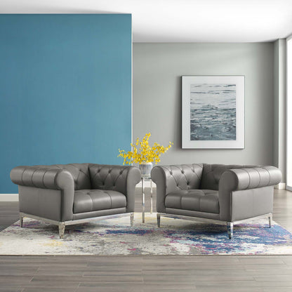 Gray tufted leather armchairs with metal legs in a modern living room, blue wall, yellow flowers, framed seascape, rug.