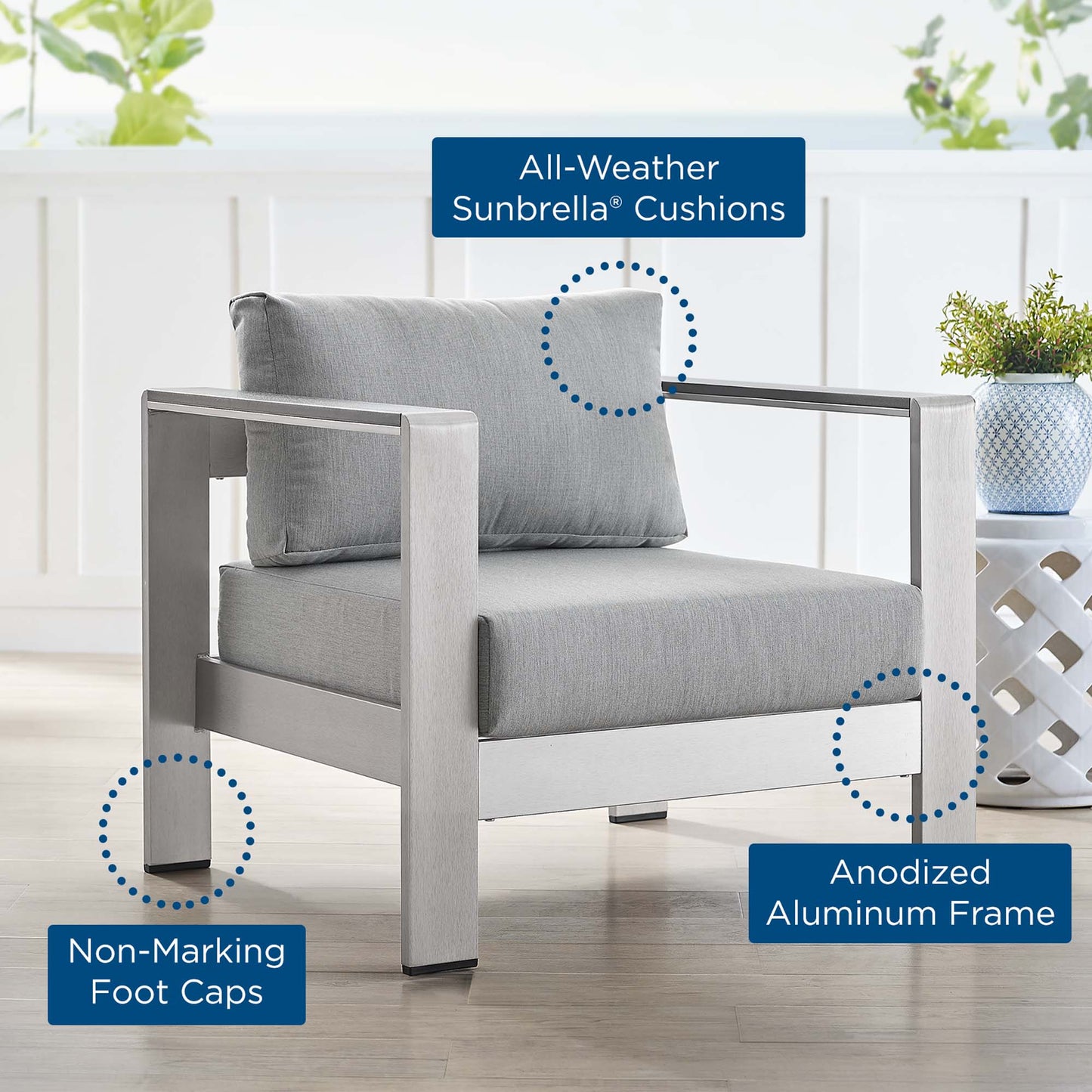 Outdoor patio armchair with light gray cushions, anodized aluminum frame, and non-marking foot caps.