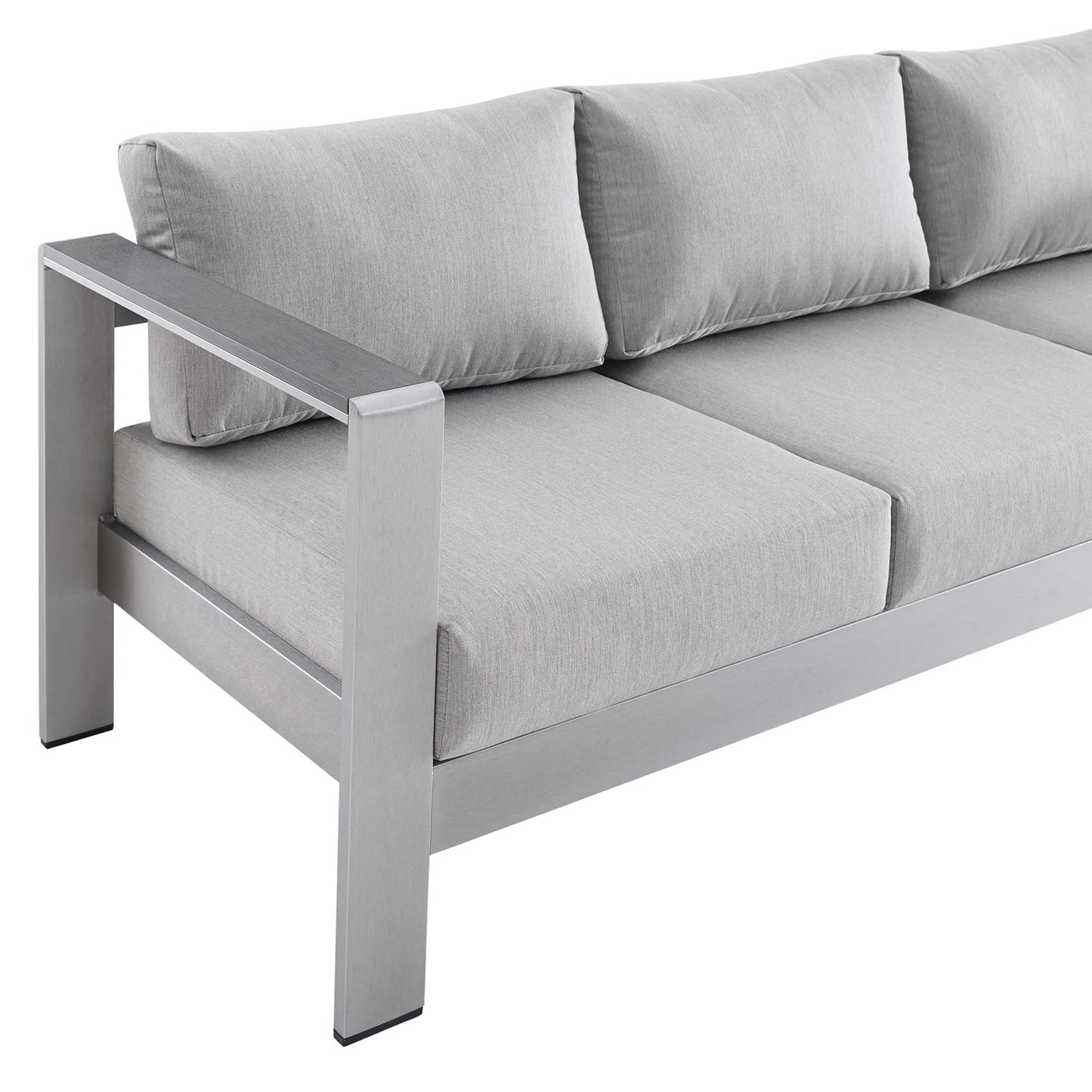 Gray framed sofa with thick light-gray cushions; modern boxy arms, outdoor lounge seating.