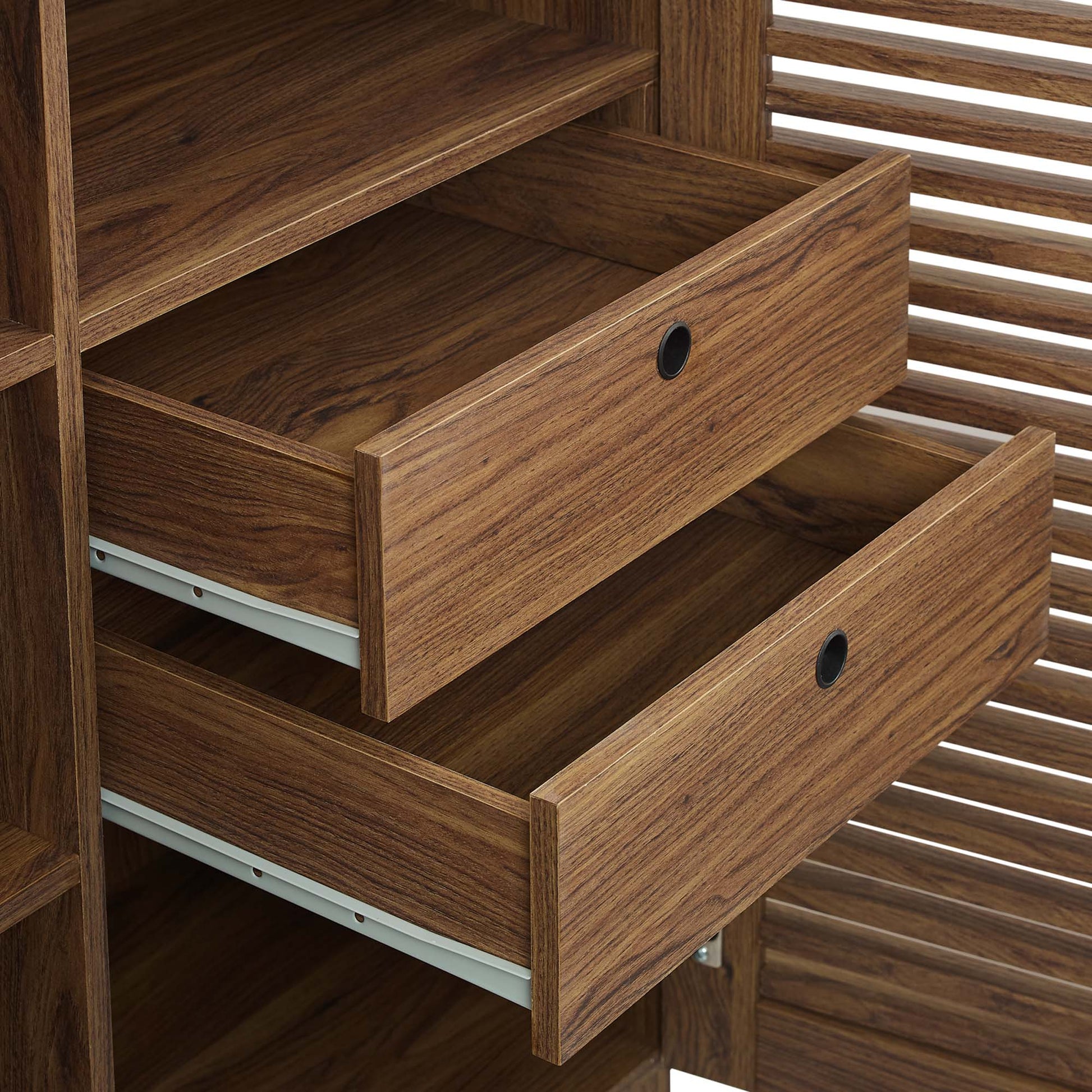 Walnut-finish wooden bar cabinet with three drawers and circular cut-out pulls, slatted sides.