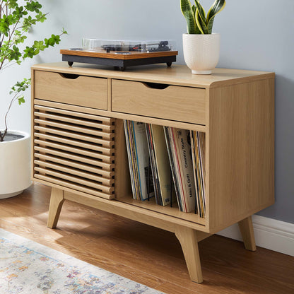 Light oak vinyl record display stand with shelving for records; top surface features a turntable and a plant.