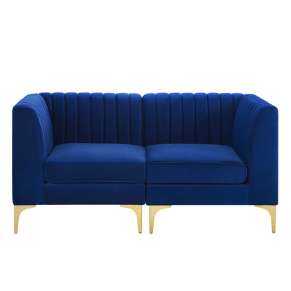 Navy blue velvet loveseat with vertical channel tufting, two cushions, rounded arms, and gold legs.