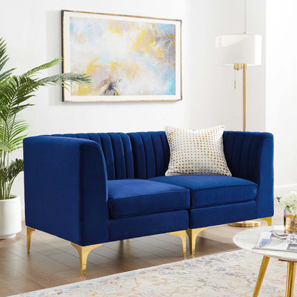 Navy blue velvet loveseat with vertical channel tufting & gold metal legs in a bright modern living room.