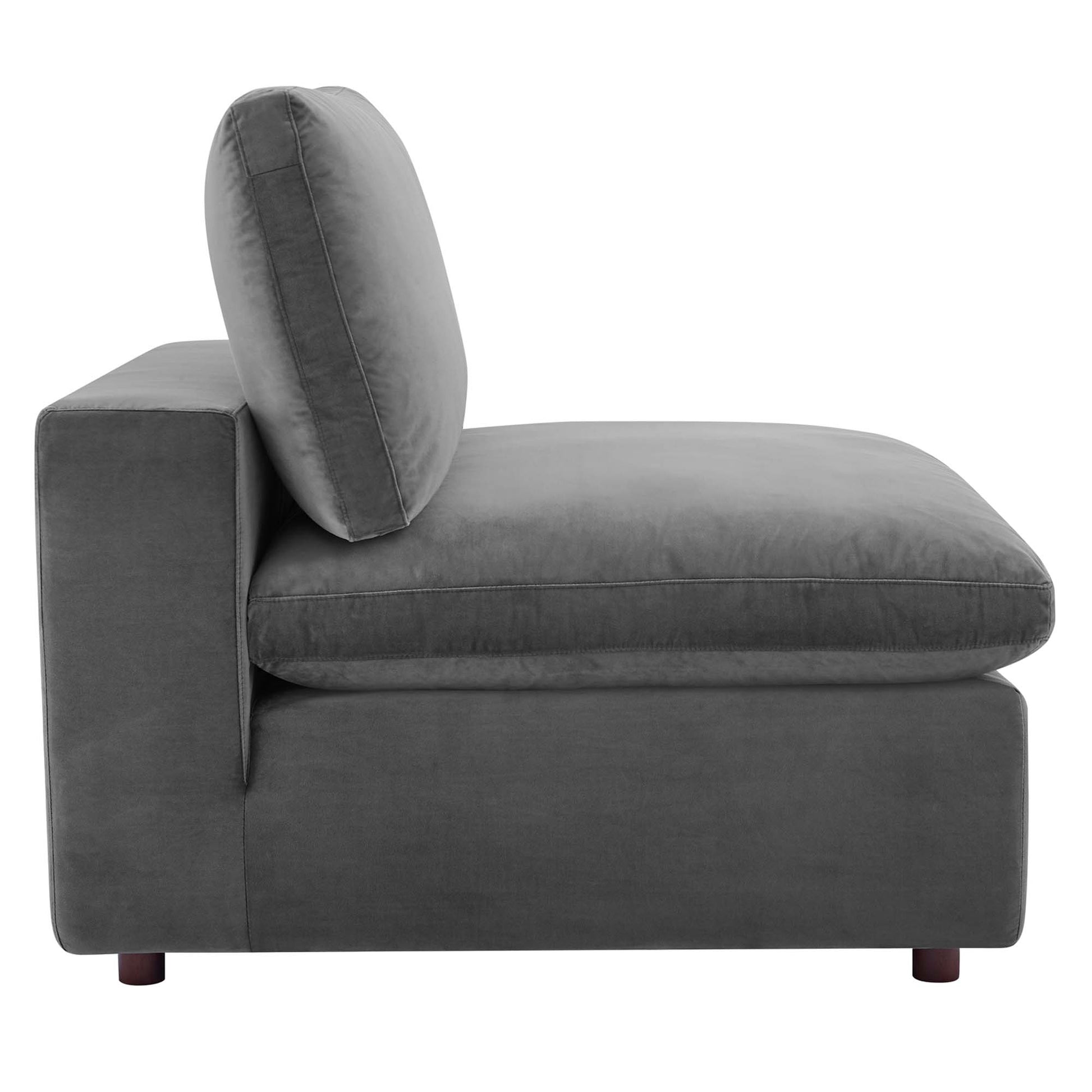 Gray velvet armless chair with a boxy silhouette, a down-filled overstuffed cushion, a single back pillow, and short wooden feet.