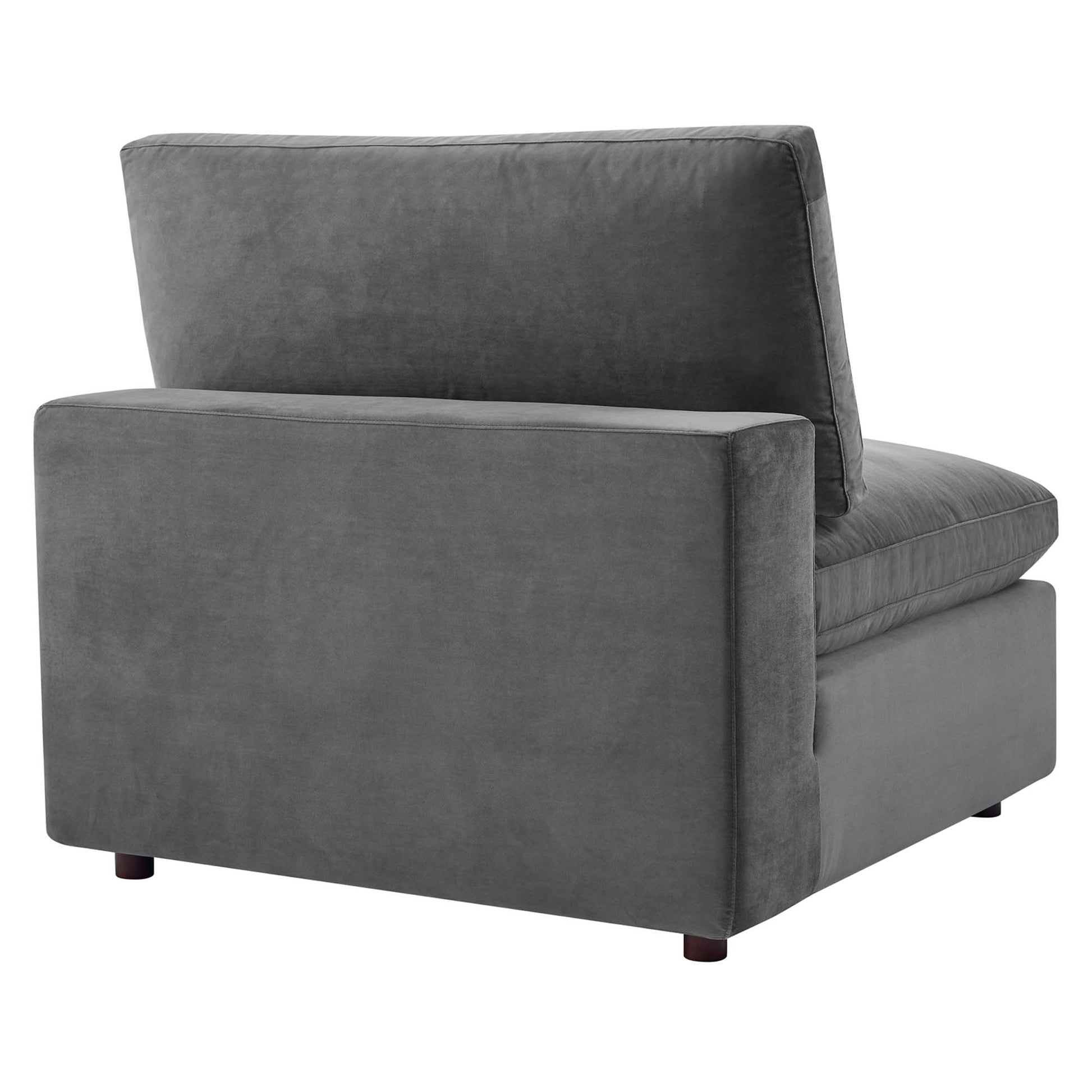 Gray velvet armless chair with cushioned back and seat and short dark wood legs.
