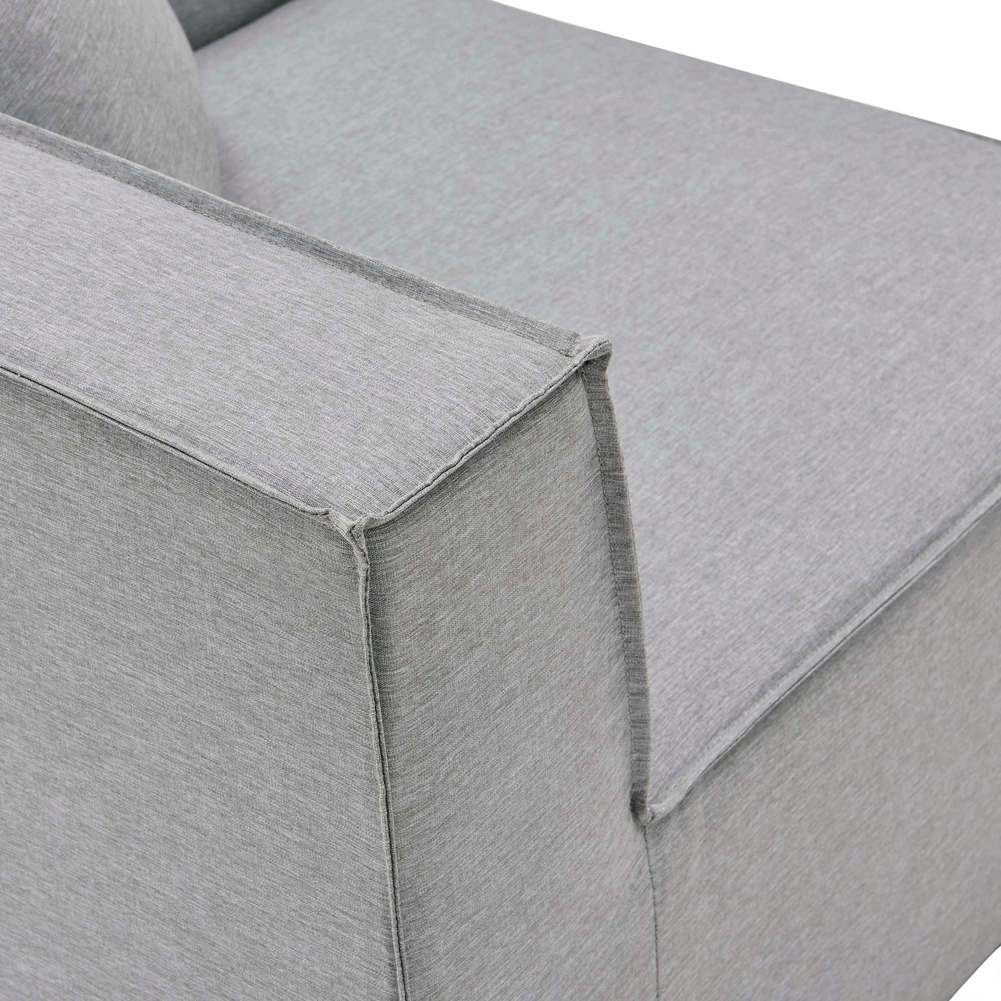 Gray textured fabric sofa armrest close-up with squared edge and cushioned seat.