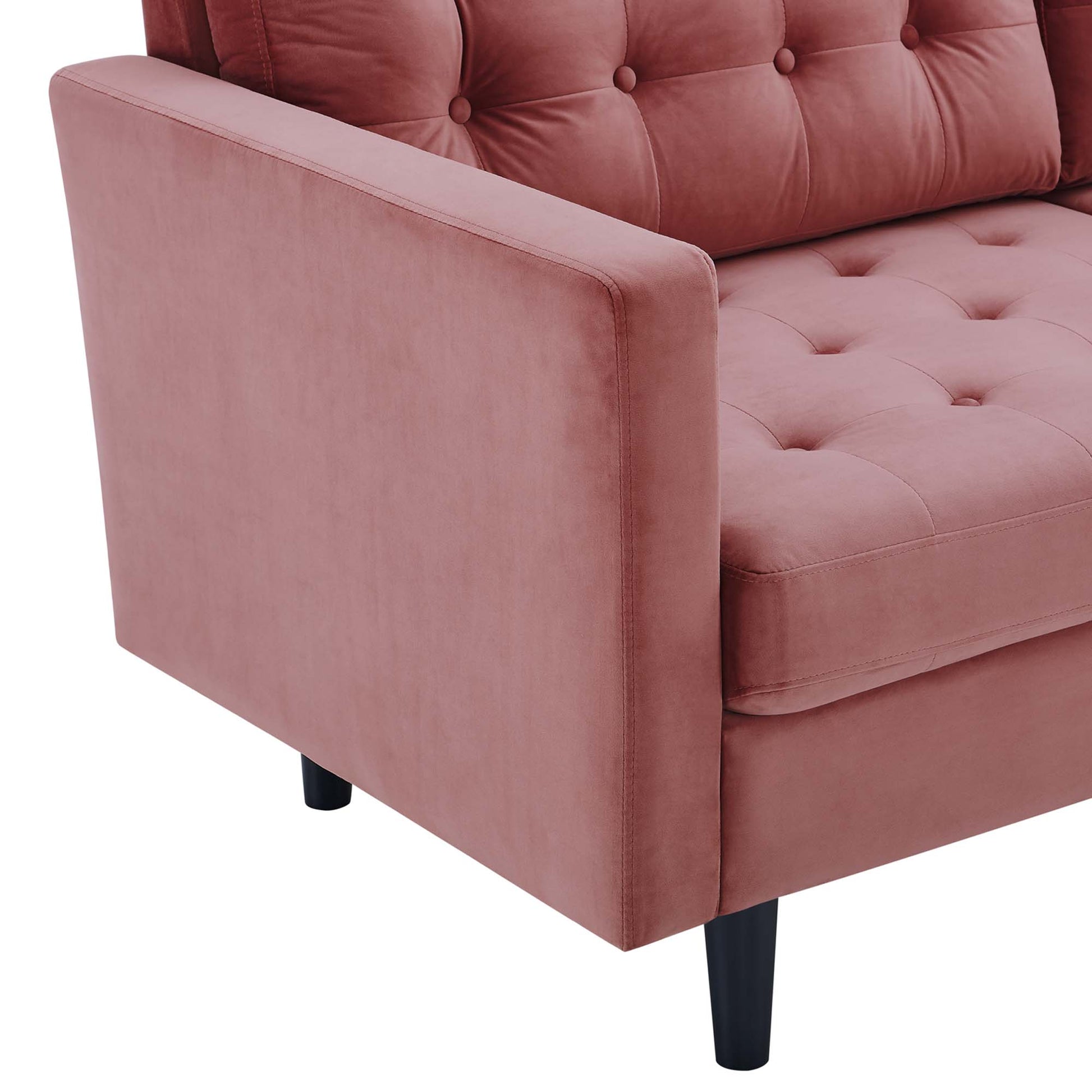 Dusty rose velvet tufted sofa with buttoned back cushions, square armrests & black tapered legs.
