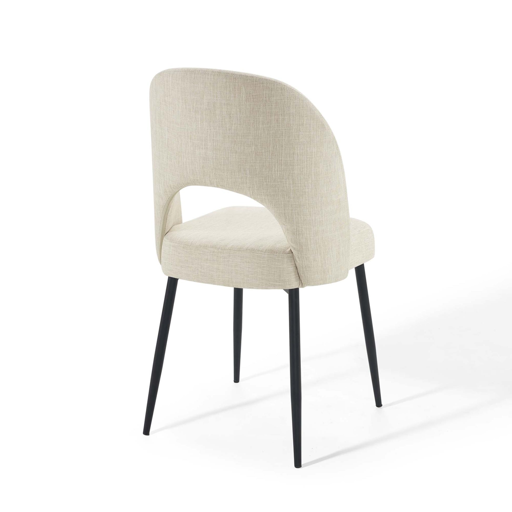 Beige upholstered dining side chair with rounded back and black tapered metal legs.