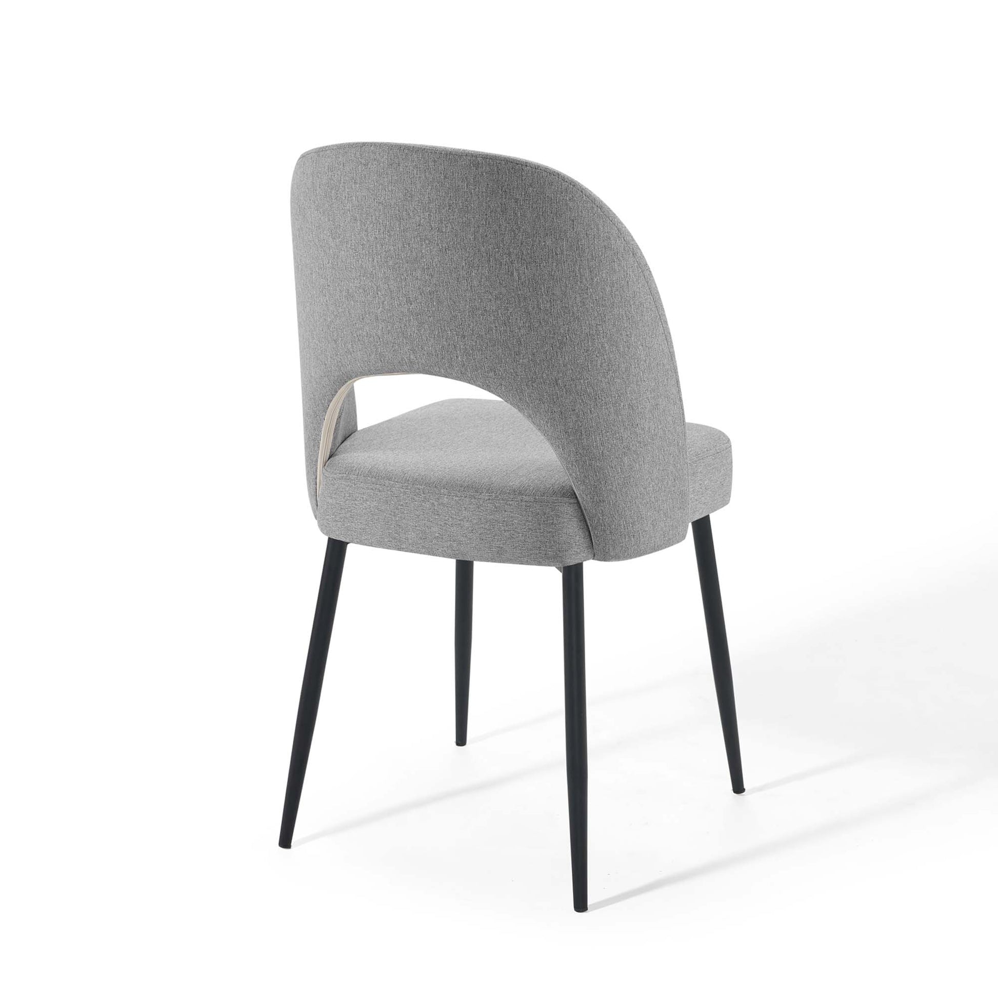 Light gray fabric dining chair with curved wraparound back and black tapered legs
